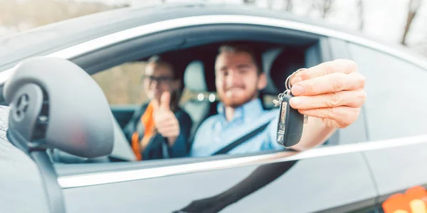 마지막 시험을 통과하여 자동차 키를 보여 주고 있는 운전 학교 학생 — 스톡 사진