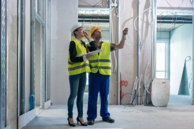 Construction worker and architect discussing work to be done at site clipart