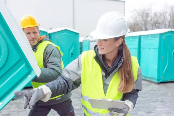 Worker loading portable toilets on truck — Stock Photo, Image