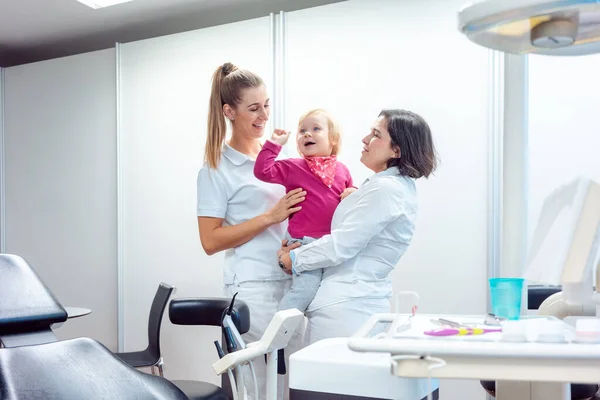 Dentysta i jej asystentka z dzieckiem w biurze — Zdjęcie stockowe