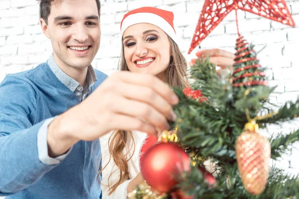 Hombre poniendo adorno de Navidad en el árbol — Foto de Stock