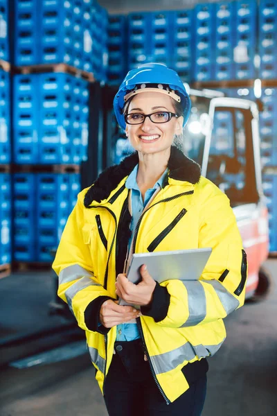 Εργαζόμενος γυναίκα σε μια εταιρεία logistics με έναν υπολογιστή tablet — Φωτογραφία Αρχείου