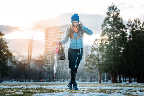 Mujer teniendo una ciudad caminando en nieve descongelada — Foto de Stock
