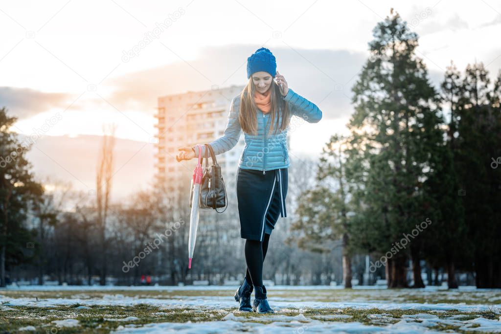 Woman having a city walk in thawing snow