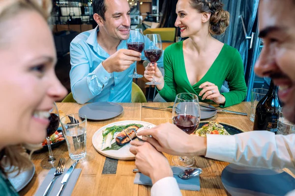 Två par njuter av mat och dryck i en restaurang — Stockfoto