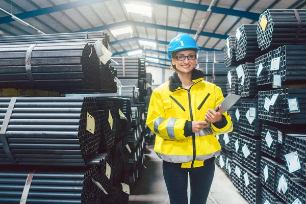 Logistiek voor bouwmaterialen - vrouw werkzaam in magazijn — Stockfoto