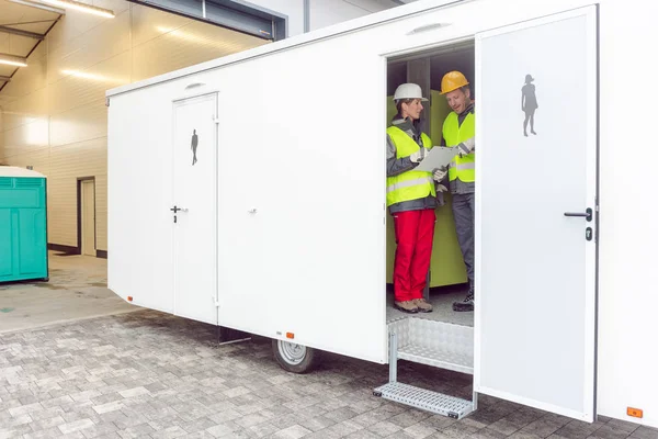 Workers inspecting a restroom trailer before renting it out — Stock Photo, Image