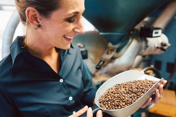 Woman in coffee roastery with fresh beans — Stock Photo, Image