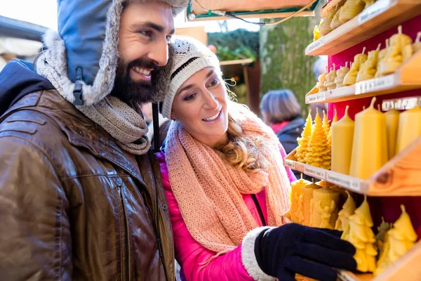 Pareja en el mercado de Navidad comprando velas como regalo — Foto de Stock