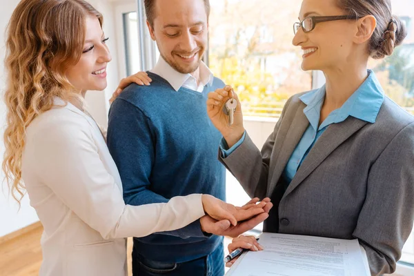 Realtor dando chave de casa para os compradores ou inquilinos — Fotografia de Stock