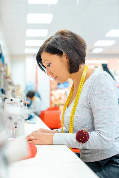 Alterations tailor in her studio working in some clothes — Stock Photo, Image
