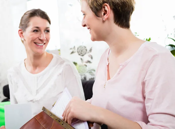 To lykkelige kvinner som sitter sammen – stockfoto