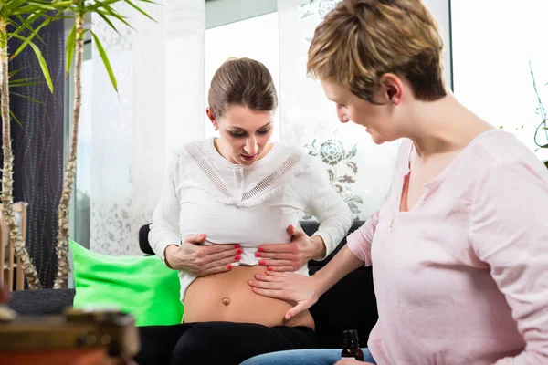 Fisioterapeuta feminina verificando a barriga das mulheres — Fotografia de Stock