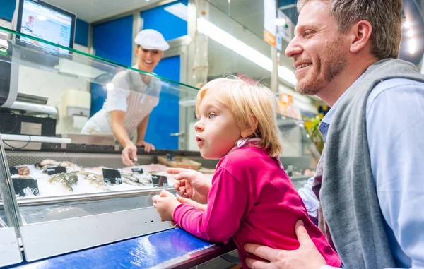 Família no balcão de peixes em um supermercado — Fotografia de Stock