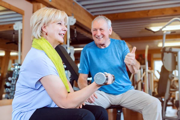 Seniorin im Fitnessstudio trainiert mit Kurzhanteln für Fitness — Stockfoto