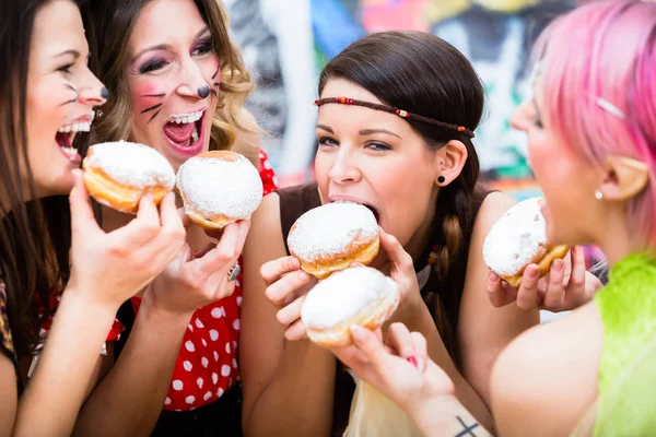 Girls at German Fasching Carnival eating doughnut-like traditional pastry — Stock Photo, Image