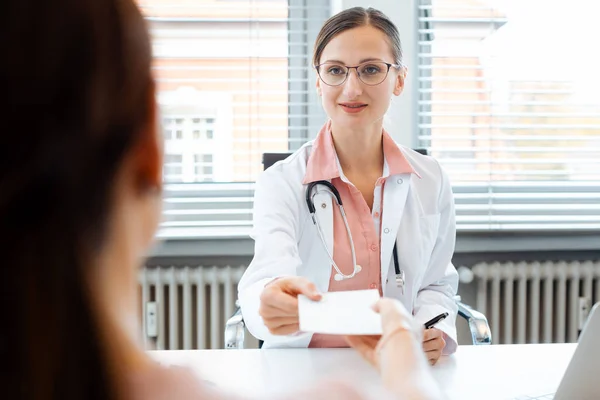 Médico entregando resbalón para medicamento recetado al paciente — Foto de Stock