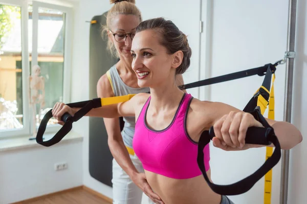 Kvinna som använder lyftsele tränare under sjukgymnastik för att återhämta sig från en skada — Stockfoto