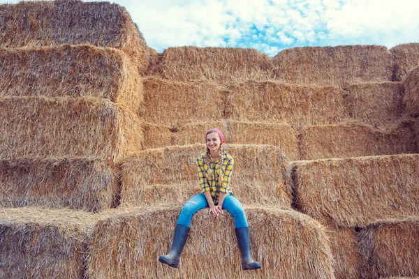 Mujer agricultora teniendo descanso en la paca de paja — Foto de Stock