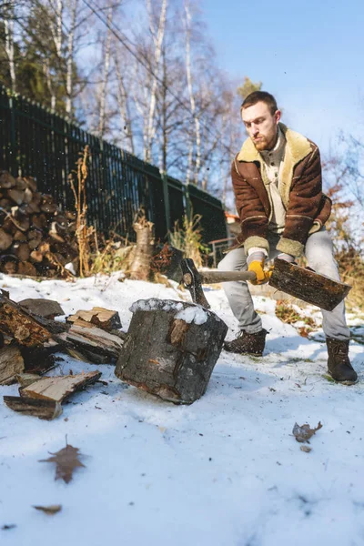Hombre cortando madera con un hacha, piezas y escombros volando alrededor —  Fotos de Stock