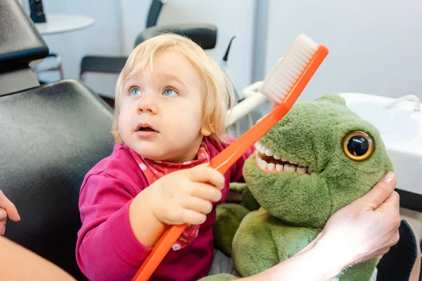 Child at the dentist brushing teeth of a plush toy — Stock Photo, Image