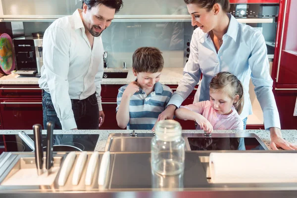 Familie testen van een nieuwe keuken die zij voornemens zijn in de showroom kopen — Stockfoto