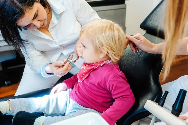 Ortodoncista revisando los dientes de un niño pequeño — Foto de Stock