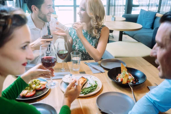 Przyjaciele w restauracji dobrze się bawią, delektując się jedzeniem. — Zdjęcie stockowe