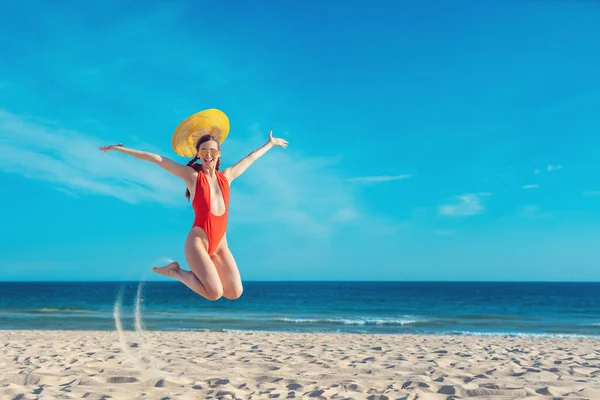 Mulher bonita desfrutando de suas férias na praia saltando alto — Fotografia de Stock