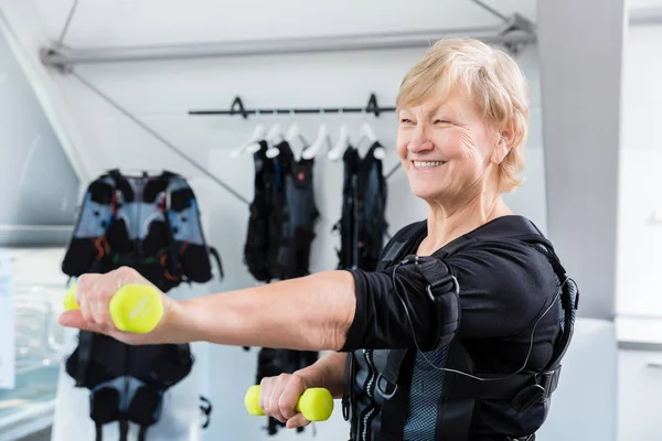 Seniorin hält sich mit Kurzhantelgymnastik im Fitnessstudio fit — Stockfoto