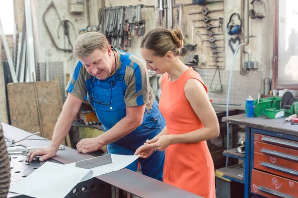 Metalworker a zákazník diskutovat plány — Stock fotografie