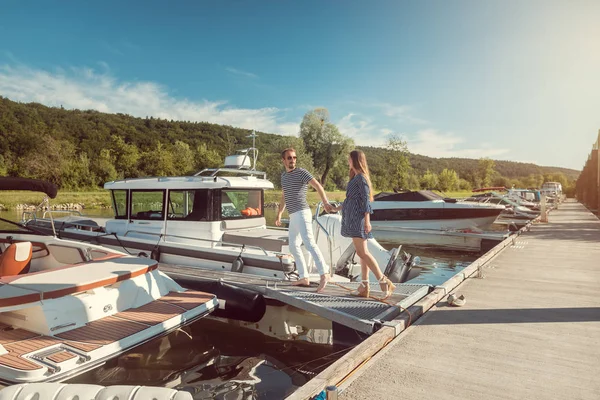 Couple entrant dans leur bateau de rivière assis dans un port — Photo