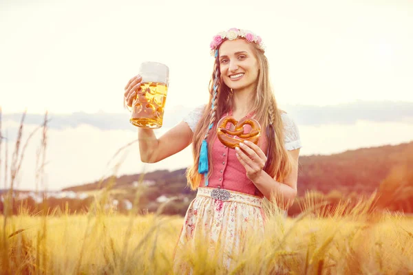 Fröhliche Bayerin mit Bier und traditionellem Essen im Sommer — Stockfoto