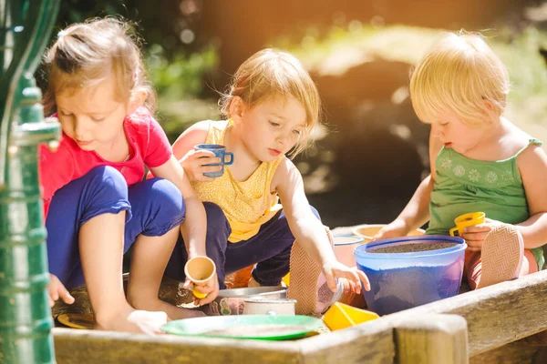 Group of girl children playing in the sandbox — Stock Photo, Image