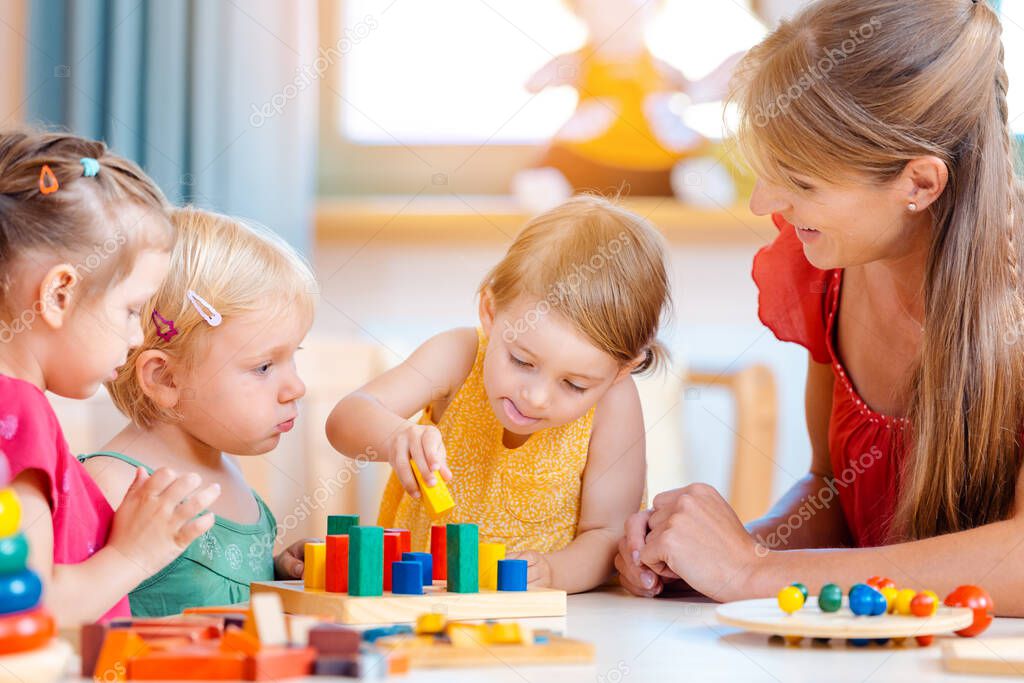 Group of children and teacher playing in kindergarten