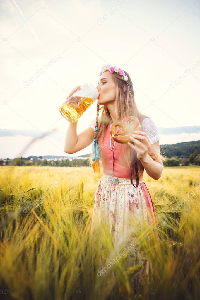 Woman in traditional clothing drinking beer in Bavaria