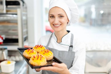 Pasta şefi küçük tartelettes üstüne kızılcık koyarak