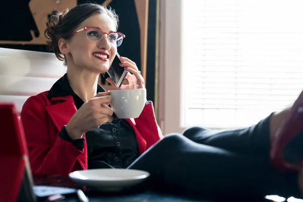 Femme d'affaires prenant un café en utilisant le téléphone — Photo