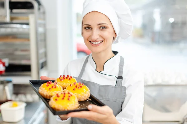 Cocinero pastelero poniendo arándanos encima de pequeñas tarteletas —  Fotos de Stock