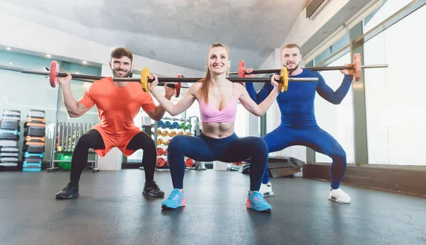 Spor salonunda ağırlık egzersizi yapan bir grup fit genç. — Stok fotoğraf