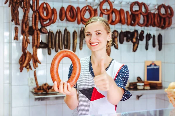 Femme vendant des saucisses donnant les pouces signe — Photo