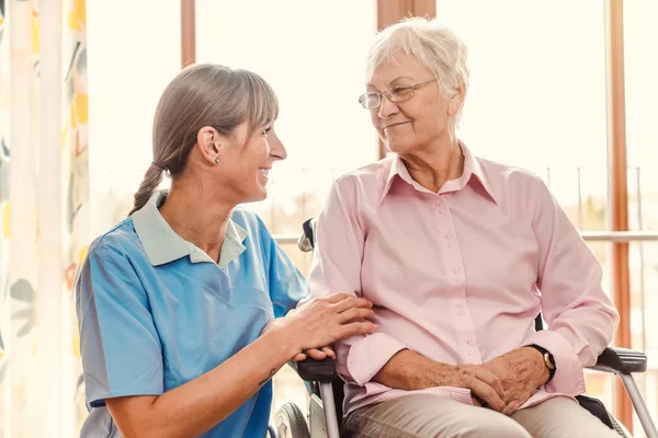 Cuidador com a mulher idosa em casa de pensão — Fotografia de Stock