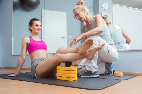 Kvinna med sjukgymnast gör fasciell träning med roll — Stockfoto