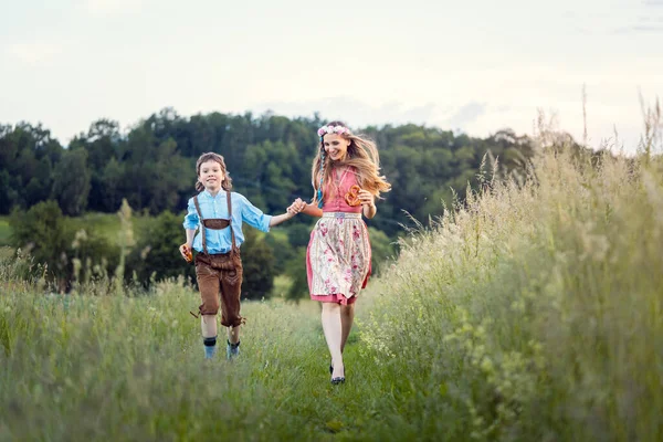 Mãe e filho na Baviera correndo por um caminho — Fotografia de Stock