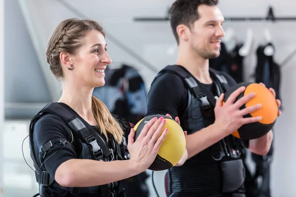 Fit woman and man with ball in wireless ems exercise gym — Stok fotoğraf