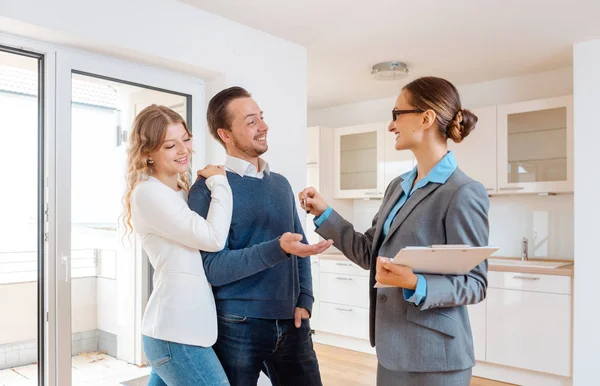 Realtor dando chave de casa para os compradores ou inquilinos — Fotografia de Stock