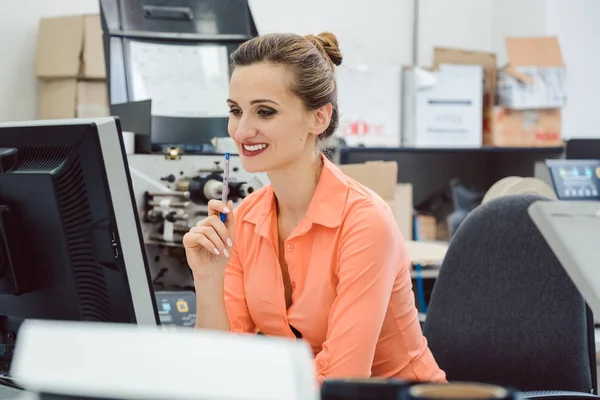 Mujer diseñando etiquetas para imprimir en la impresora de etiquetas en el taller — Foto de Stock