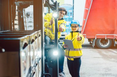 Forklift sürücüsü ve ustabaşı teslimatın nerede yapılacağını tartışıyor