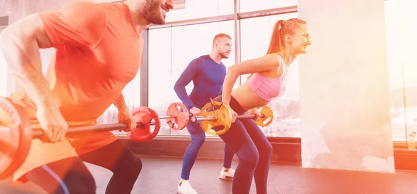 Personas con campanas en el gimnasio entrenando su músculo bíceps — Foto de Stock