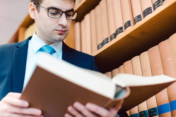 Právník v jeho kanceláři čtení precedenty v silných knih — Stock fotografie